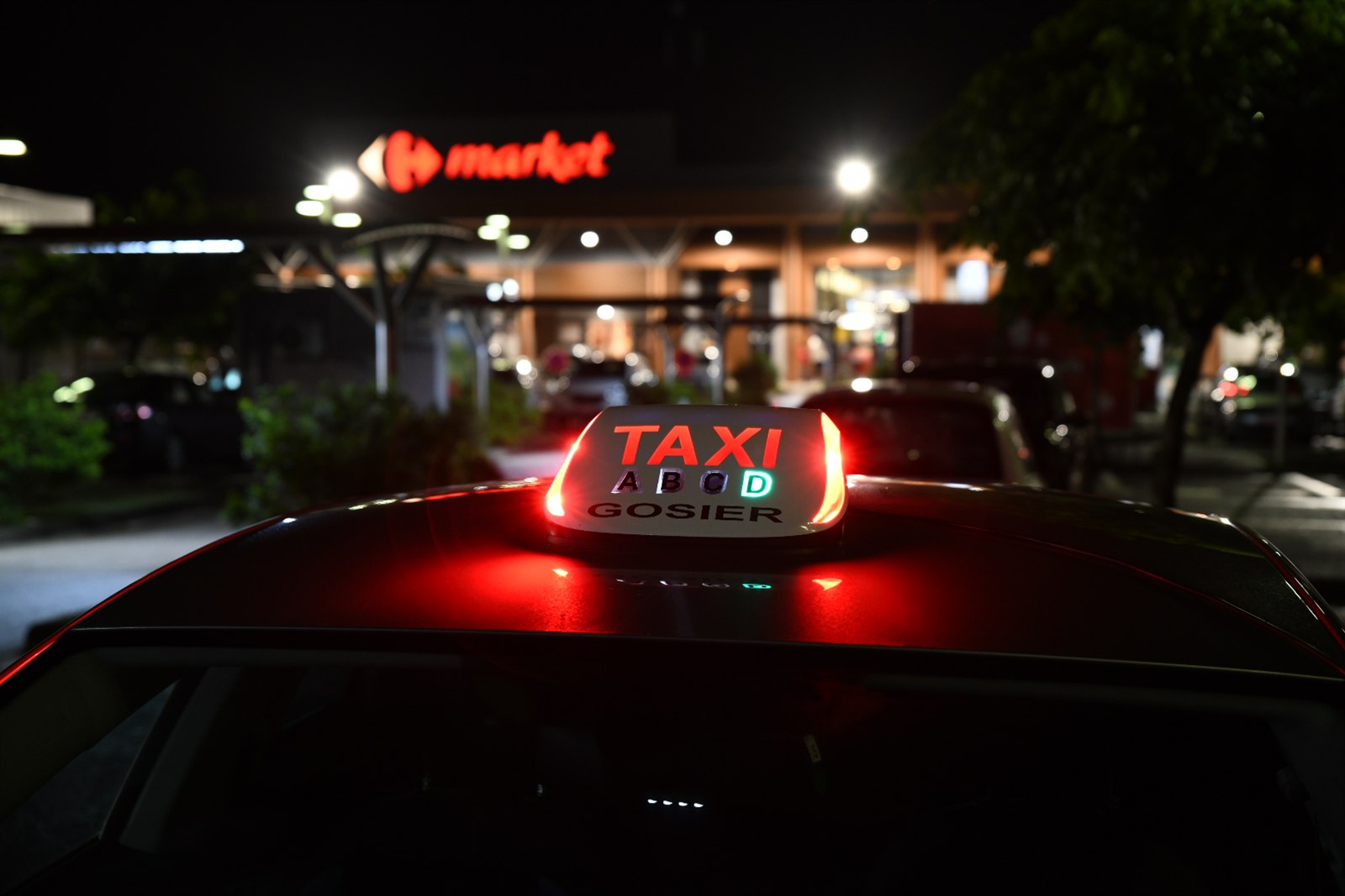 Le lumineux TAXI GOSIER éclairé sur le toit du véhicule, photographié de nuit
